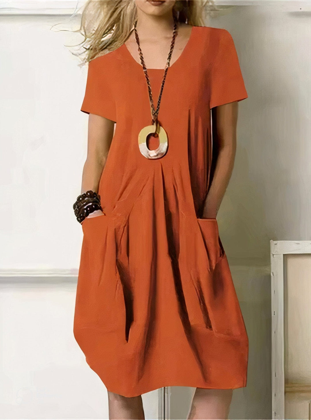 A woman wearing the relaxed Kwani flow dress, an easy travel outfit that stays cool and comfortable through a long warm weather day