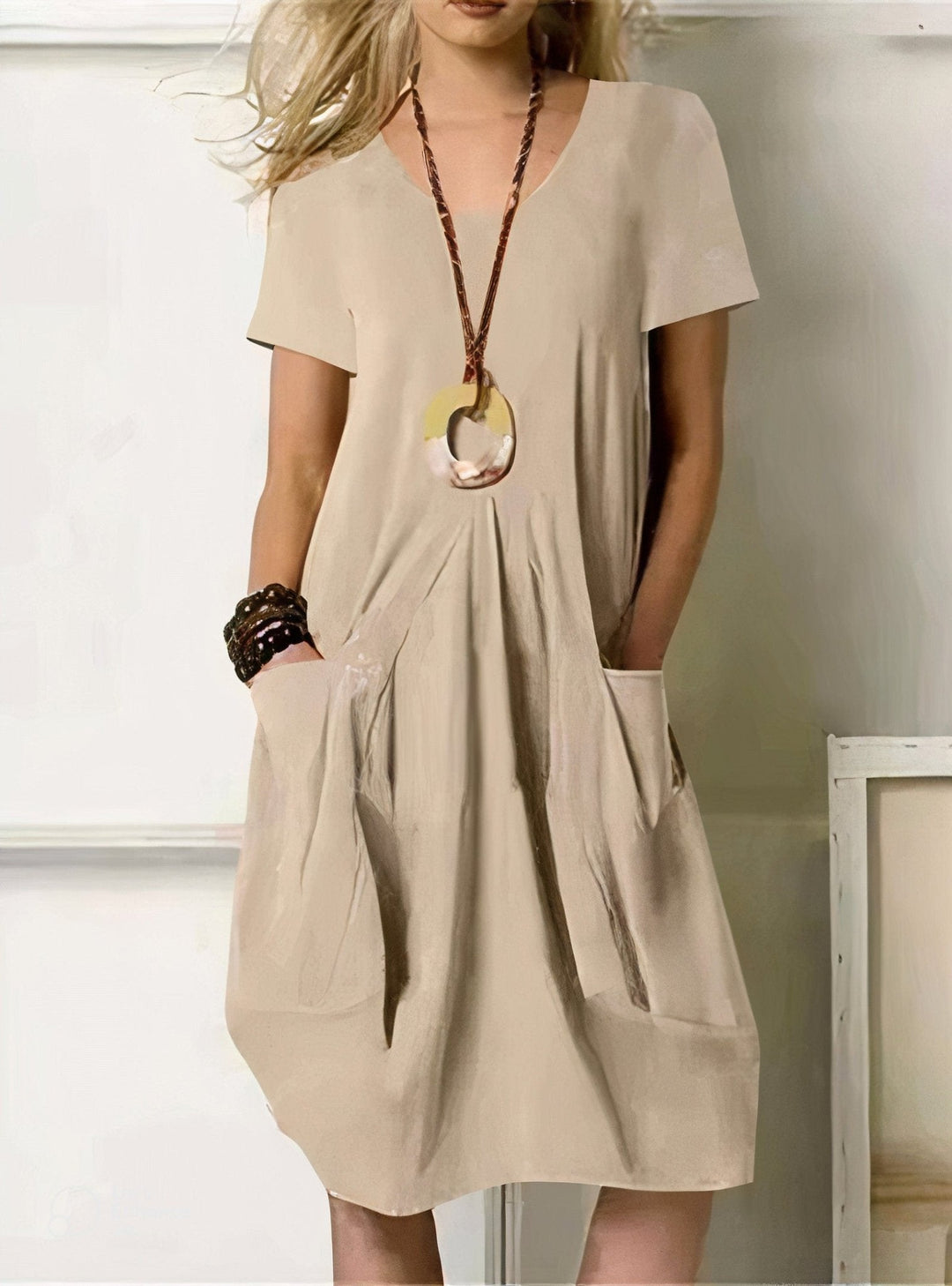 Woman wearing a relaxed black flow dress outdoors in soft summer light, dressed comfortably for a warm weather celebration